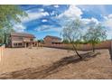 Large, low-maintenance backyard enclosed by a block wall fence with a tree at 22074 W Papago St, Buckeye, AZ 85326