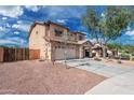 Exterior view of a two-story home with a spacious driveway and low-maintenance landscaping at 22074 W Papago St, Buckeye, AZ 85326