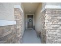 Inviting front porch featuring stone pillars, decorative wreath and a 'Welcome' sign at 23018 E Mewes Rd, Queen Creek, AZ 85142
