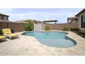 Backyard oasis featuring a sparkling pool and surrounding desert landscaping at 23018 E Mewes Rd, Queen Creek, AZ 85142