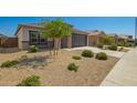 Beautiful single-story home with desert landscaping, manicured bushes and a two-car garage at 24627 W Ripple Rd, Buckeye, AZ 85326