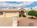 Charming beige home with a two-car garage, desert landscaping, a tile roof, and mature trees at 24907 S Lakestar Dr, Sun Lakes, AZ 85248