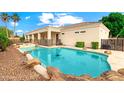 Backyard oasis with a sparkling pool, rock features, and covered patio, perfect for outdoor entertaining and relaxation at 2625 N 24Th St # 22, Mesa, AZ 85213