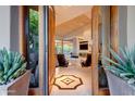 Grand entryway with tiled floor, wood doors, and a view into the living room with a fireplace and seating at 39032 N 101St Way, Scottsdale, AZ 85262