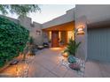 Inviting front entrance with desert landscaping, a stone walkway, potted plants, and a cozy seating area at 39032 N 101St Way, Scottsdale, AZ 85262
