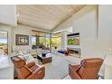 Bright living room features vaulted wood ceilings, modern fireplace, and large windows with views of the desert landscape at 39032 N 101St Way, Scottsdale, AZ 85262
