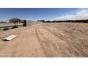 Vacant lot ready for construction with cinderblock wall at rear and utilities connection at 46819 W Old Timer Rd, Maricopa, AZ 85139