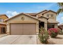 Charming two-story home with a two car garage and landscaped front yard with colorful shrubs at 5220 W Desert Ln, Laveen, AZ 85339