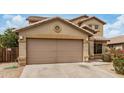 Beige two-story home with a two-car garage and desert landscaping at 5220 W Desert Ln, Laveen, AZ 85339