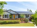 Exterior of a beautiful home featuring a bright yellow door and solar panels on the roof at 546 W Cambridge Ave, Phoenix, AZ 85003