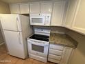 Functional kitchen featuring modern appliances, including a refrigerator, microwave, and stove with granite countertops at 7126 N 19Th Ave # 108, Phoenix, AZ 85021