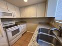 Well-lit kitchen with granite countertops, white cabinets, stainless steel sink, and modern appliances at 7126 N 19Th Ave # 108, Phoenix, AZ 85021