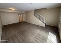 Spacious living room area showcasing neutral walls, carpet, and access to a stairway and a doorway at 7126 N 19Th Ave # 108, Phoenix, AZ 85021