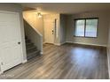 Light-filled living room featuring wood floors, a staircase, and a large window at 8514 S 49Th Dr, Laveen, AZ 85339