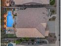 Aerial view of a beautiful backyard with a sparkling pool, spa, and green spaces at 9702 E Naranja Ave, Mesa, AZ 85209