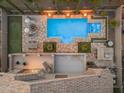 Aerial view showcases the backyard with a pool, spa, putting green, and outdoor kitchen at 9702 E Naranja Ave, Mesa, AZ 85209