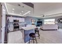 Open kitchen and living area with a breakfast bar and stainless steel appliances at 11069 E Kilarea Ave # 194, Mesa, AZ 85209