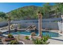 Backyard swimming pool featuring a rock waterfall and lush landscaping at 11446 E Sweetwater Ave, Scottsdale, AZ 85259