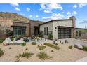 Inviting single-story home with desert landscaping and a cozy front patio with fire pit and lounge furniture at 14551 N Adero Canyon Dr, Fountain Hills, AZ 85268