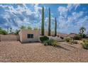 Single-story home with desert landscaping, mature trees, blue trimmed window and two car garage at 14627 N 55Th Pl, Scottsdale, AZ 85254