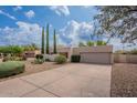 Single-story home featuring a two-car garage, xeriscaped yard and mature landscaping under a cloudy blue sky at 14627 N 55Th Pl, Scottsdale, AZ 85254