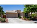 Inviting single-story home with a tile roof, desert landscaping, and an attached garage at 18575 W Vogel Ave, Goodyear, AZ 85338