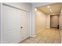 Bright hallway with tiled flooring, closet, and a view of the front door at 18575 W Vogel Ave, Goodyear, AZ 85338