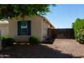 The side of the home with a gravel area, small trees and fencing at 18575 W Vogel Ave, Goodyear, AZ 85338