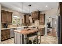 Elegant kitchen with custom cabinetry, a farmhouse sink, granite counters, and an island with seating at 198 N Pecan Ct, Gilbert, AZ 85234
