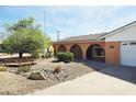 Charming single-Gathering home featuring stucco walls, arched doorway and windows, xeriscaping, and a driveway leading to a garage at 2027 N 81St St, Scottsdale, AZ 85257