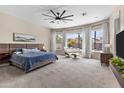 Spacious main bedroom boasts large windows, a ceiling fan, and a comfortable seating area at 2105 E San Carlos Pl, Chandler, AZ 85249