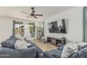 Spacious living room boasts cozy seating, natural light, and a ceiling fan at 21610 N Bradford Dr, Maricopa, AZ 85138