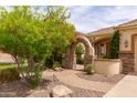 Charming front yard featuring a stone archway, brick pathway, and vibrant, mature landscaping at 2203 E Tonto Pl, Chandler, AZ 85249