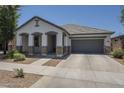 Attractive home with a two-car garage, covered porch, and low maintenance desert landscaping at 22463 E Desert Spoon Dr, Queen Creek, AZ 85142