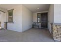 Covered front porch featuring decorative stone pillars, a bench, and a charming welcome mat at 22463 E Desert Spoon Dr, Queen Creek, AZ 85142