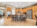 Eat-in kitchen with stainless appliances, wood cabinets, tile backsplash, and seating at the island at 2959 W Eastman Dr, Anthem, AZ 85086