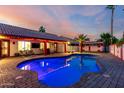 Inviting backyard oasis featuring a sparkling pool, lush landscaping, and covered patio area for relaxing at 3037 E Mallory St, Mesa, AZ 85213