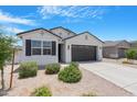 Charming single-story home with desert landscaping, black shutters, and a modern two-car garage at 35585 W San Alvarez Ave, Maricopa, AZ 85138