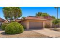 Lovely home with a well-manicured yard and a two-car garage, featuring a red tile roof and desert landscaping at 4346 E Bannock St, Phoenix, AZ 85044