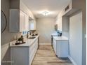 Updated kitchen with white cabinets, sleek countertops, stainless steel appliances, and modern fixtures at 5222 N 41St Ave, Phoenix, AZ 85019