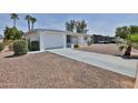 Inviting single-story home with desert landscaping, a spacious driveway, and a tidy facade at 5510 E Dallas St, Mesa, AZ 85205