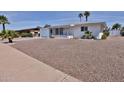Single-story white home featuring desert landscaping, a front porch, and an attached garage at 5510 E Dallas St, Mesa, AZ 85205