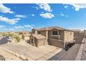 Aerial view of a stucco home featuring large garage, stone accents and basketball hoop, situated in a neighborhood at 6202 W Maya Dr, Phoenix, AZ 85083