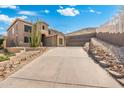 Two-story house showcasing desert landscaping, a concrete driveway leading to a garage, and a hillside backdrop at 6202 W Maya Dr, Phoenix, AZ 85083