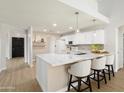 Bright open kitchen with white cabinets, quartz countertops, stainless appliances, and island seating at 6366 W Saint John Ave, Glendale, AZ 85308