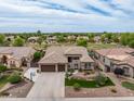 Expansive home featuring a three-car garage, lush landscaping, and a well-maintained lawn in a golf course community at 654 E County Down Dr, Chandler, AZ 85249