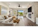 Spacious living room with stone fireplace, hardwood floors, and sliding glass doors to the backyard at 654 E County Down Dr, Chandler, AZ 85249