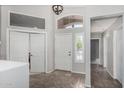 Bright foyer featuring tiled flooring, white doors, and transom window at 7456 W Irma Ln, Glendale, AZ 85308