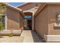 View of the home's front entrance with a covered entryway and attractive desert landscaping at 7456 W Irma Ln, Glendale, AZ 85308