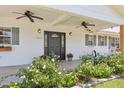 Inviting front porch with dual ceiling fans, rocking chairs, and beautiful flower beds at 7607 N 17Th Ave, Phoenix, AZ 85021